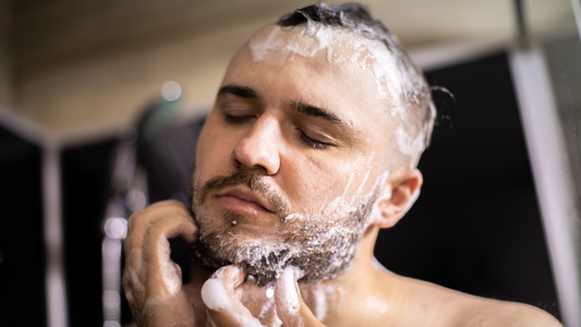 A man washing his beard with beard wash.