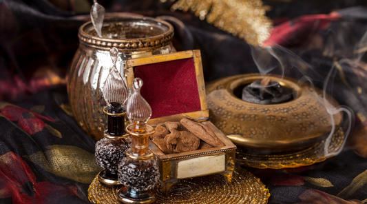 Incense burning, a gold box with wood chips and glass bottles with fragrance and essentials oils.