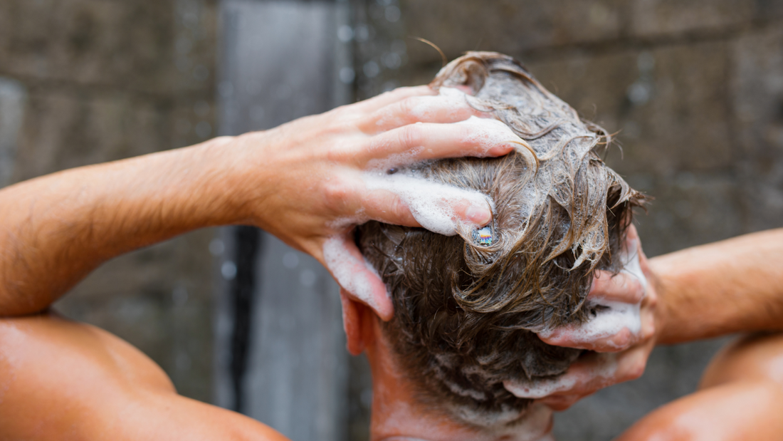 A man shampooing his hair with lots of lather.