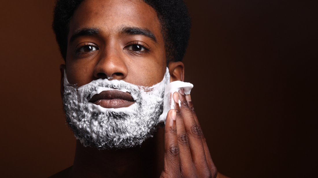 Man spreading shave soap lather on his face.